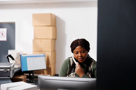 Storage room employee having remote discussion with customer during storehouse inventory. African...