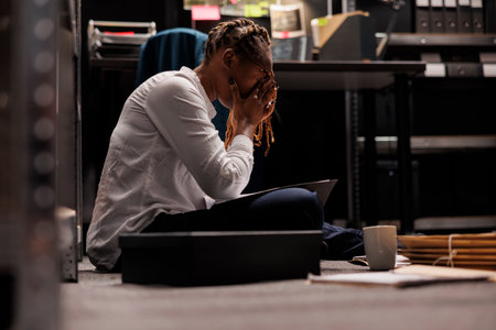 Private detective with eyes pain working late analyzing crime case file. Exhausted police agent...