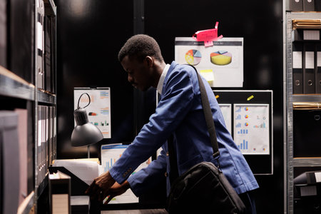 African american officer pack his stuff preparing to leave job, working late at night at...