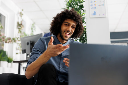 Start up company project manager telecommuting, chatting with customer in online meeting on laptop....