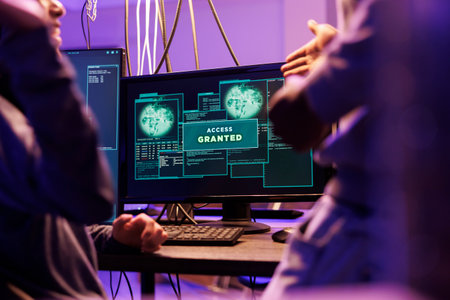 Access granted message on hackers computer screen after breaking into online server. Two criminals happy successful network system password hacking notification on monitorの写真素材