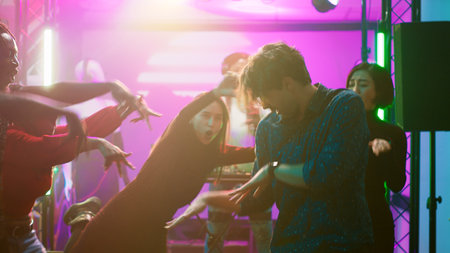 People starting fun dance battle at club, having fun together at party with electronic music....