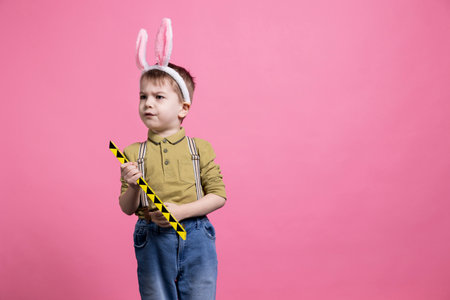 Upset little toddler playing with a toy and being displeased about something, wearing a pair of...