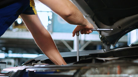 Close up shot on torque wrench used by certified mechanic in car service to tighten bolts after...