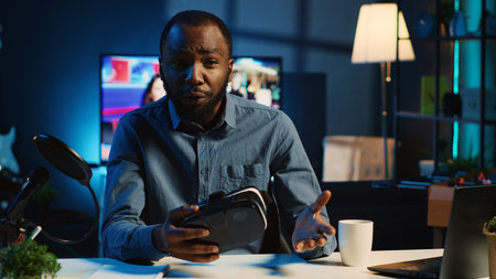 Tech content creator filming technology review of newly released VR glasses, unpacking them and presenting specifications to audience. Influencer showing virtual reality goggles to subscribersの写真素材
