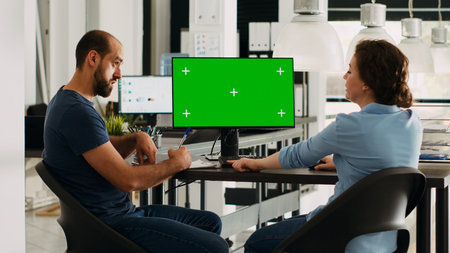 Startup team looking at pc with greenscreen, small business office desk. Company workers analyzing...