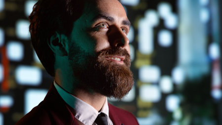 Entrepreneur strolling around town and admiring urban buildings near city center, businessman on night promenade. Confident man walking under streetlamps on sidewalk, downtown district. Handheld shot.の写真素材