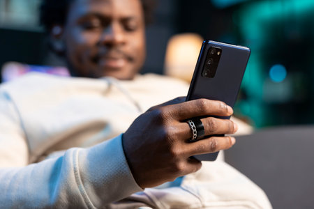 Close up of cellphone held by person chatting with online friends, enjoying himself at home. Focus...