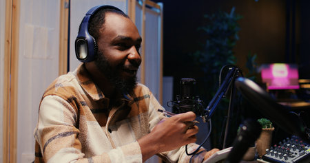 Zoom in on african american man on podcast discussing with guest during marathon stream for humanitarian cause. Host chatting with celebrity, gathering donations from audience during internet showの写真素材