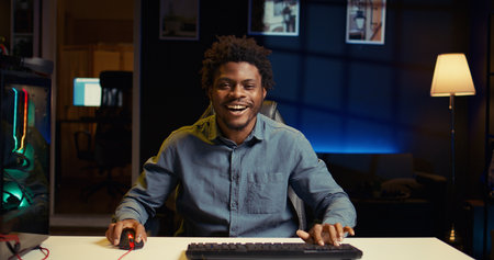 Excited gamer feeling happy after receiving winner screen on PC for killing all enemies and finishing level. Delighted player bragging after being victorious in gaming computer videogameの写真素材