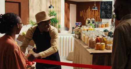 Local merchant opening grocery store doors and welcoming clients, greeting people with new organic...