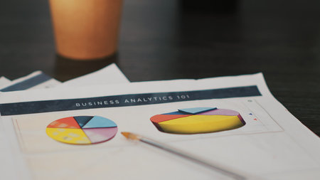 Paperwork on office desk containing business financial information such as balance sheets and income statements, extreme close up shot. Company invoice documents in accounting workspaceの写真素材