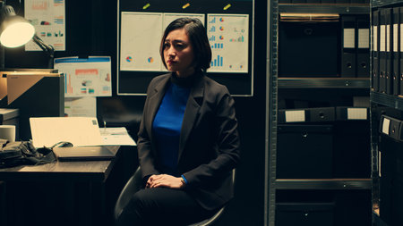 Inspector checks holographic photos captured in real time, police department investigating crime with artificial intelligence and 3d visual projections. Officer uses hologram in dark room. Camera A.の写真素材