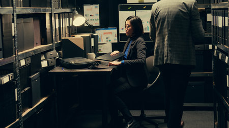 Woman detective arriving at job to solve police investigation, entering archive room to work on criminal case. Asian investigator recreating crime scenes based on archived evidence. Camera B.の写真素材