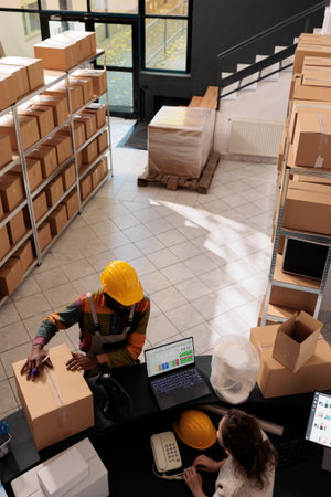 Diverse employees standing at counter desk in stockroom, preparing customer order for delivery....