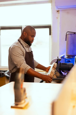 Carpenter selecting high quality wood materials, ensuring they align with project requirements. Cabinetmaker doing quality assurance on lumber block, ensuring it can be used for furniture assemblingの写真素材