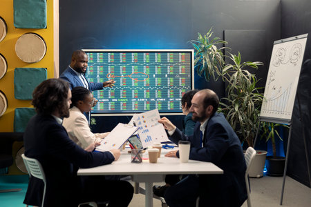 Team of business employees study feedback on old initiatives to improve their work for the future, developing new strategies in coworking space conference room. Marketing organization activity.の写真素材