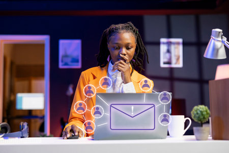 African american woman working on laptop, sending emails to business partners, online connectivity concept. Remote worker using XR augmented reality tech to interact with notebook screenの写真素材