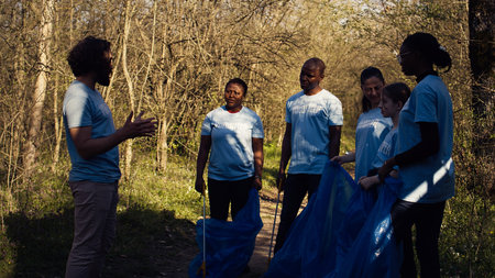 Team of activists picking up plastic waste to recycle and collect rubbish, cleaning the forest natural environment for conservation. People doing voluntary work to save the planet. Camera B.の写真素材