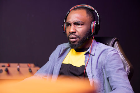 Gamer frustrated after losing internet esports videogame match, being outsmarted by rival players. Dejected man looking in disheartened manner at game over message on desktop PC screenの写真素材