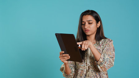 Woman trying to do purchases, frustrated with error received while adding payment method on website, studio background. Upset person unable to do internet shopping, getting card rejected, camera Aの写真素材