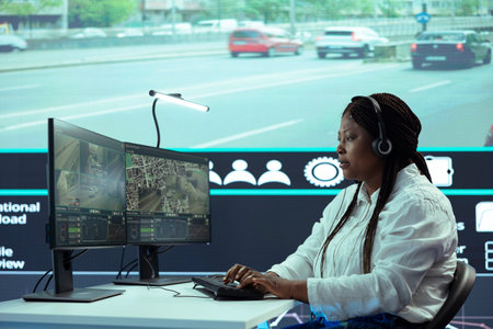 African american government associate monitoring cars in traffic via real time surveillance footage...