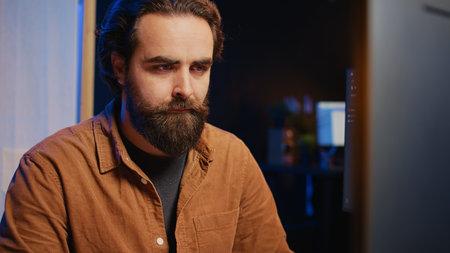 Software technician in apartment office deeply immersed in coding on computer at desk, close up. IT...