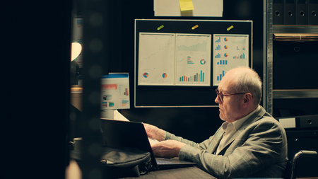 Private inspector uses web technology to access digital archives and databases in incident room, classified records on laptop. Paralyzed detective helps department with investigative leads. Camera A.の写真素材