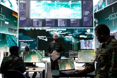 Female trooper working with federal reconnaissance satellite system in command center power base, examining real time battlefield data for the infantry units. Operator in general headquarters.の写真素材