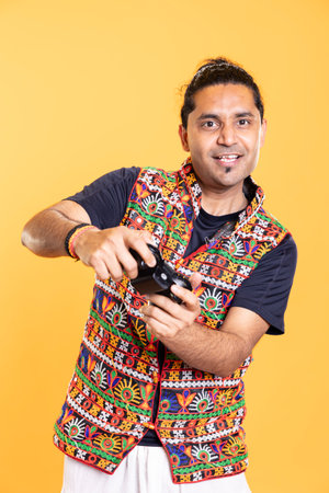 Portrait of focused gamer holding controller, concentrating on finishing videogame level. Man pressing gamepad buttons, spamming attacks, solving quests, isolated over studio backdropの写真素材