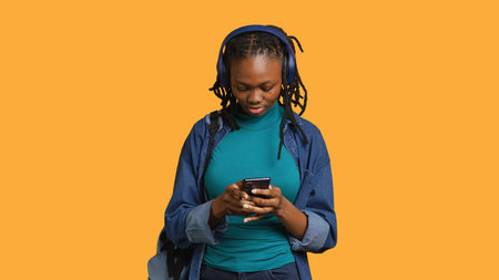Smiling woman discussing with friends during teleconference meeting using smartphone and headphones,...