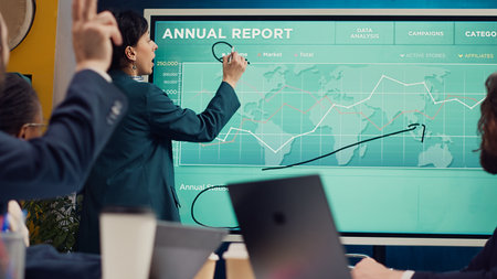 Office administrator presenting data reports and funding on interactive board, deliberating on income analysis with her associates. Accomplishing enterprise financial objectives. Camera A.の写真素材