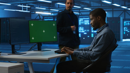 Technician upgrading equipment in data center using isolated screen display. Professional at PC desk...
