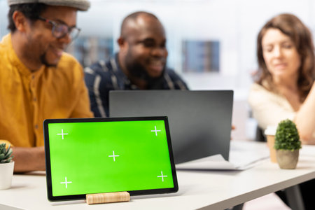 Real estate agent presenting urban building layout next to green screen, discussing about a high class office space leasing for business relocation. Clients looking to invest in property.の写真素材