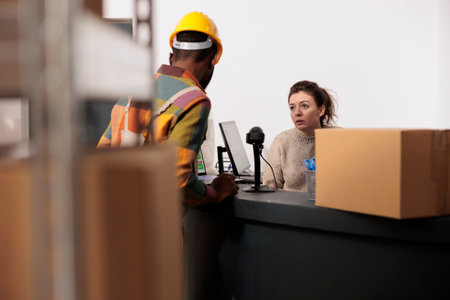 Stockroom team discussing merchandise inventory report, working at products quality control in warehouse. Diverse employees checking online orders preparing customers packages in storage roomの写真素材