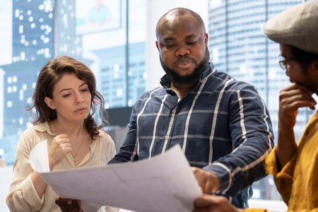 Businessman sharing his vision for the new office space with the realtors, planning to make an investment for startup development and relocation. Office tour with blueprints to reach agreement.の写真素材