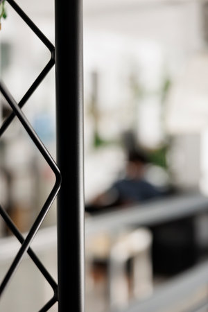 Start up unicorn business office with employee working on blurred background. Company executive manager worker in modern open space workplace selective focus with metal rack close upの写真素材