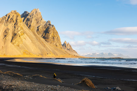 Huge vestrahorn mountains connect with ocean, beautiful nordic setting with natural black sand beach. Icelandic stokksnes peninsula with rocky hills and breathtaking scenic route.の写真素材