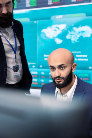 Financial analyst works on resource allocation plans with his staff, analyzing reports and sales infographics to find revenue. Achieve objectives in a competitive business environment.の写真素材