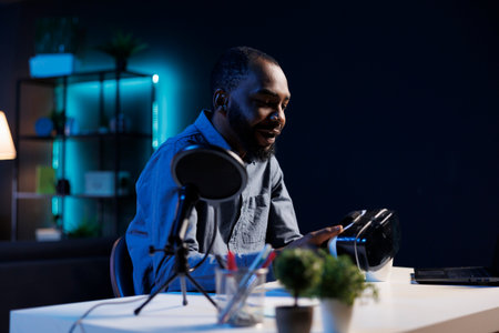 BIPOC tech content creator filming technology review of newly released VR glasses, unpacking them and presenting specifications to audience. Influencer showing virtual reality headset to subscribersの写真素材