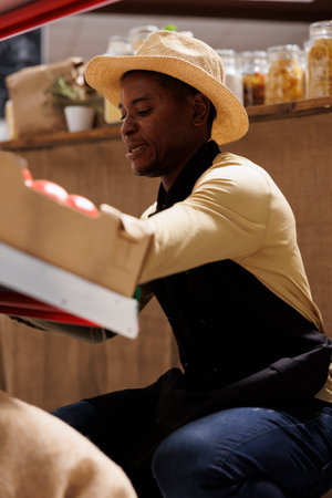 African American business owner arranges eco friendly products in supermarket. Detailed image of a...