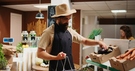 Storekeeper arriving in green living bio supermarket with freshly harvested farm grown food. Vendor...