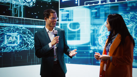 Presenter and specialist guest talking at AI summit bringing together tech startups professionals, exploring latest developments in artificial intelligence and deep learning technology, camera Bの写真素材