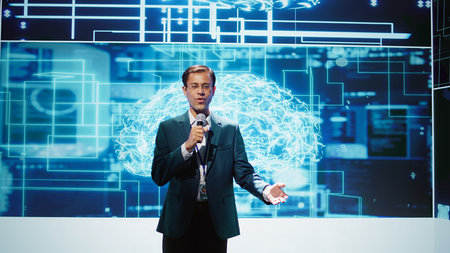 Upbeat presenter inviting engineer on stage during global IT conference to talk about subjects such...