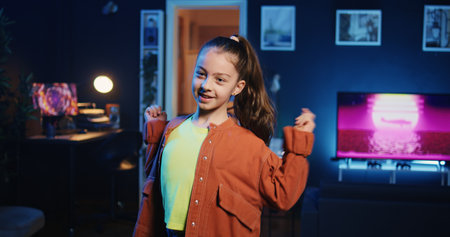 Zoom in and out shot of talented kid getting tons of engagement on her dancing clips posts on social media platforms. Media star child filming viral videos, impressing audiences with dance movesの写真素材