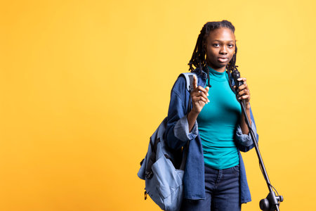 Portrait of african american motivational speaker talking in microphone, addressing audience, isolated over studio background. Expressive BIPOC lecturer using mic, inspiring motivationの写真素材