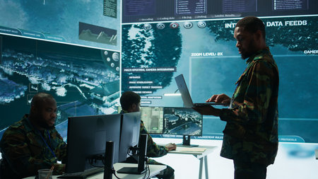 Military officers work in a high tech army control tower base, managing surveillance imagery from cctv satellite. Soldiers handle data protection to ensure national security. Camera B.の写真素材