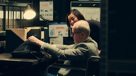 Senior investigator with chronic disability works on legal case, developing customized assistive tools for archive room tasks. Detective analyzing forensic evidence for details. Camera A.の写真素材