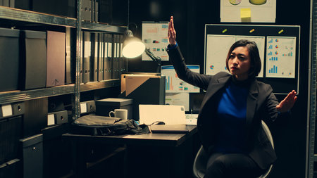 Private officer examines holographic projection of 3d suspect visualization, working with augmented reality on crime case. Agent looks at hologram with AI illustration, advanced tools. Camera A.の写真素材