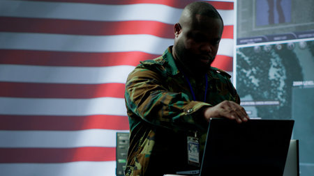 US military personnel work in a modern army command post, safeguarding classified information and state secrets against cyber attacks. Digital warfare and cybersecurity operations. Camera A.の写真素材